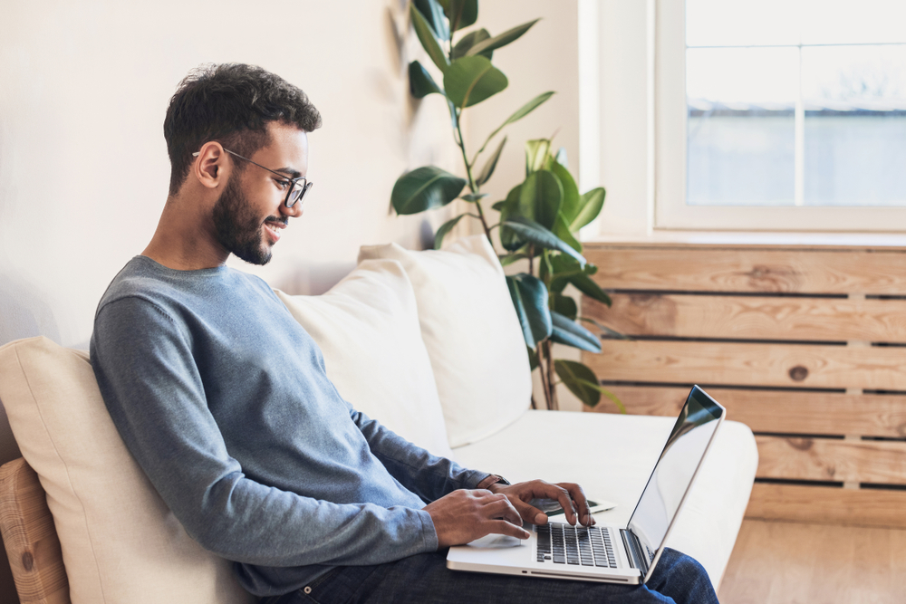 Educação a distância - foto de um homem estudando pelo computador sentado no sofá
